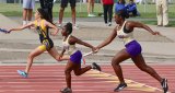 Lemoore's Amaya Sanchez hands the baton off to Iiyanii Jones during the 4x100 relay during Friday night's track and field invitational in Tiger Stadium. The Lemoore team finished third.